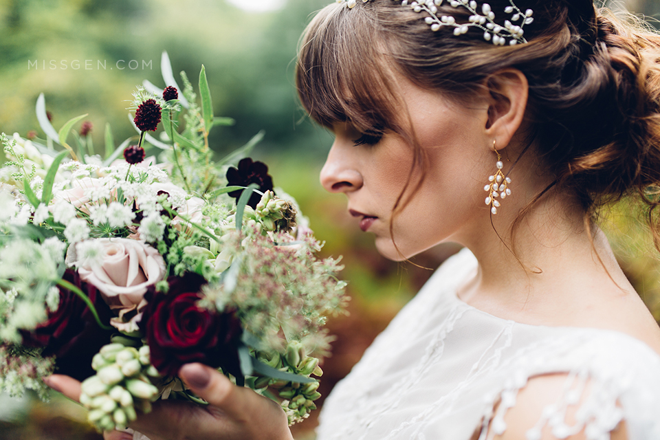 Close up of Bride's face with wild forest bouquet, wearing Kelly Spence earings and pearl crown and dress by Faith Caton Barber. Woodland elopement inspiration by Miss Gen Photography, London and destination creative reportage wedding photographer.