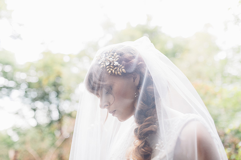 bride wearing veil in the woods