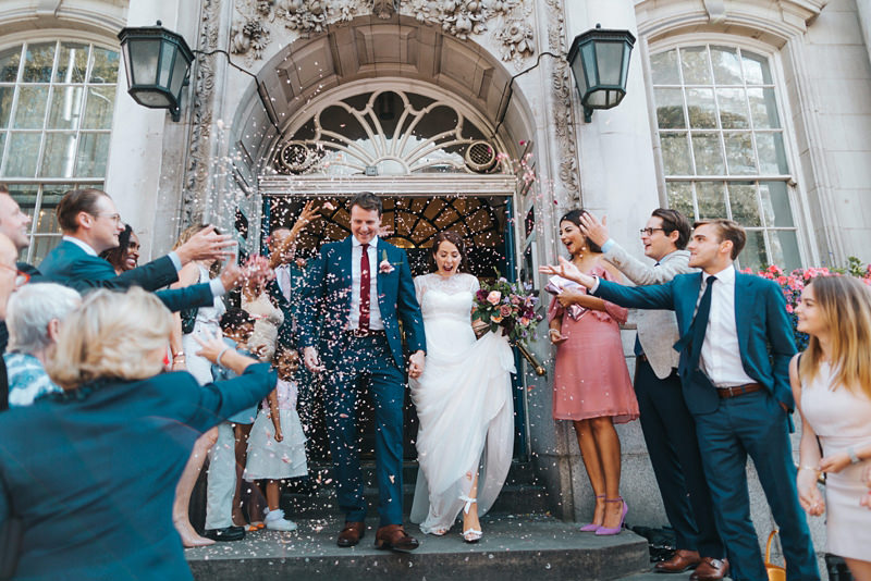 bride and groom with confetti on the steps of chelsea town hall by London wedding photographer Miss Gen