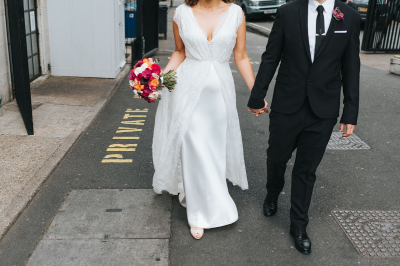bride and groom walking down street in london by alternative modern wedding photographer miss gen
