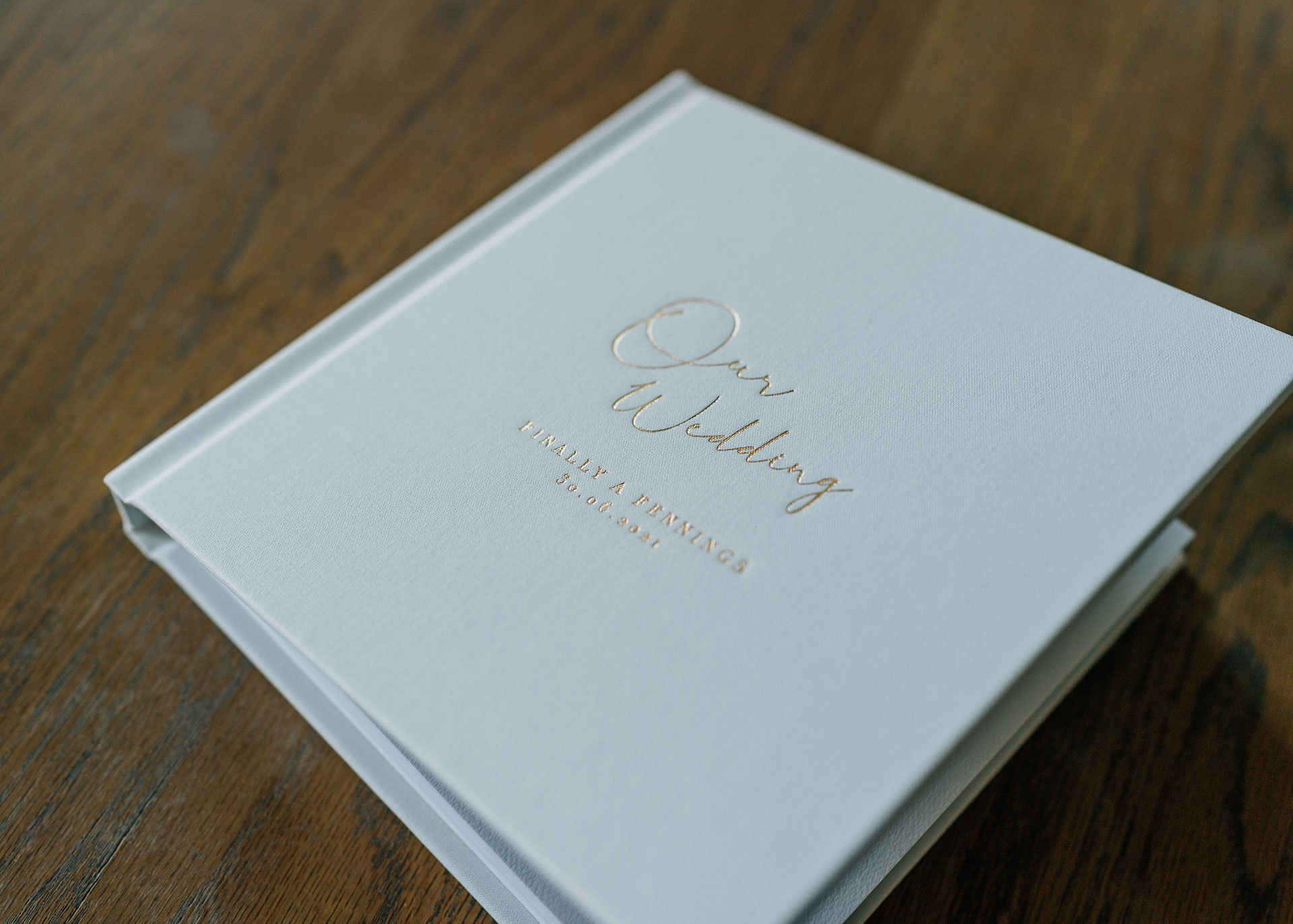 A Fine Art Wedding Album in white fabric with gold debossing on the cover by Miss Gen
