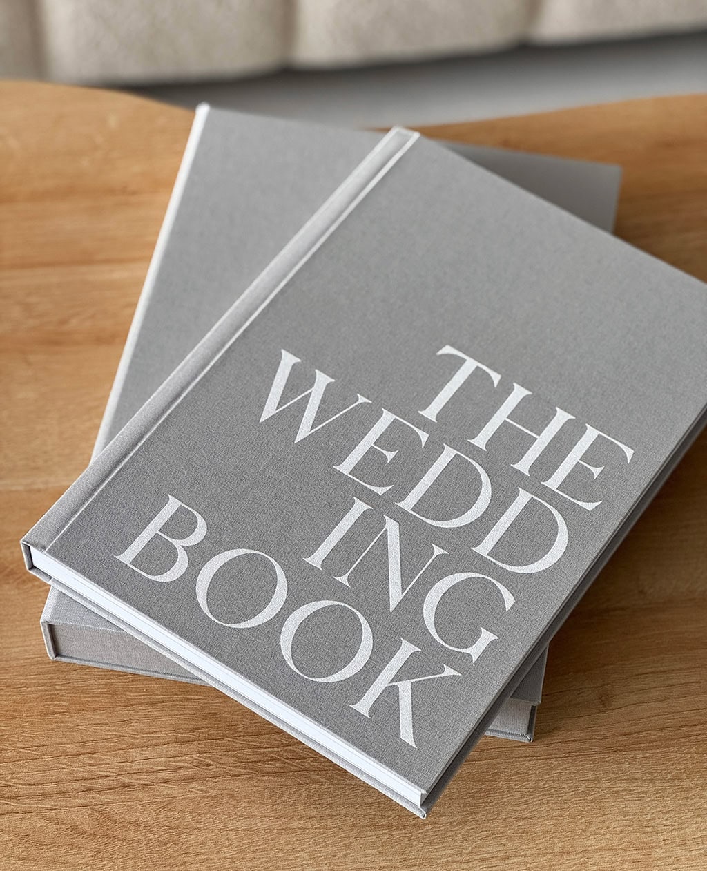 A personalised photography fine art paper coffee table book with grey fabric cover and white screen printed cover design complete with matching slipcase.